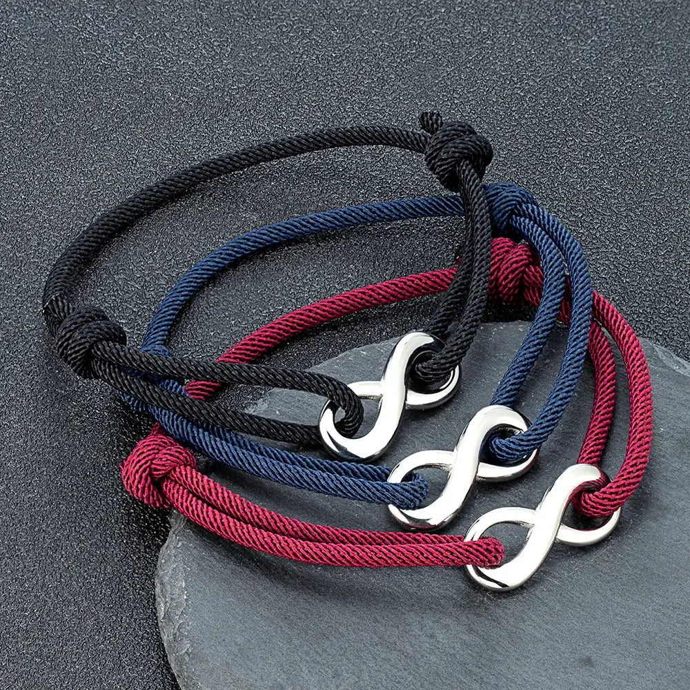 Bracelets infini ajustables en acier inoxydable blanc et cordons noir, bleu foncé et rouge bordeaux posées.