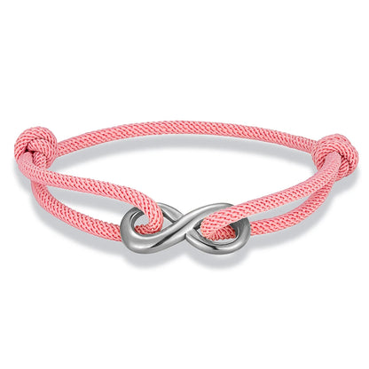 Bracelet infini ajustable en acier inoxydable blanc et cordon rose clair sur fond blanc.