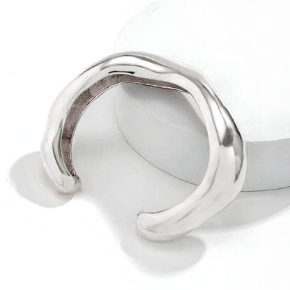 Bracelet jonc courbé en or blanc posé.