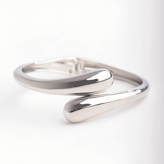 Bracelet jonc goutte d'eau en or blanc sur fond blanc.