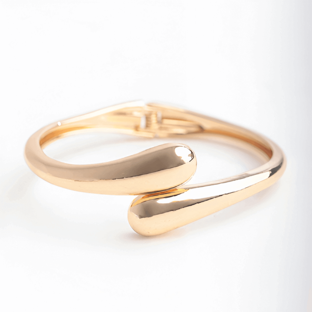 Bracelet jonc goutte d'eau en or jaune sur fond blanc.