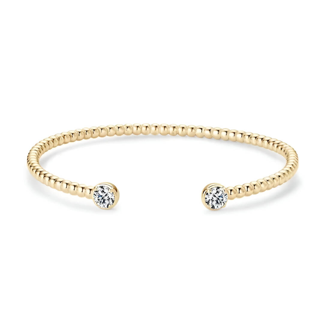 Jonc granulé en argent 925 plaqué or jaune et double diamants en moissanite forme ronde sur fond blanc.
