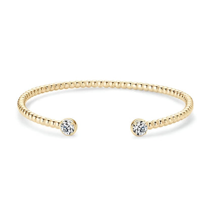 Jonc granulé en argent 925 plaqué or jaune et double diamants en moissanite forme ronde sur fond blanc.