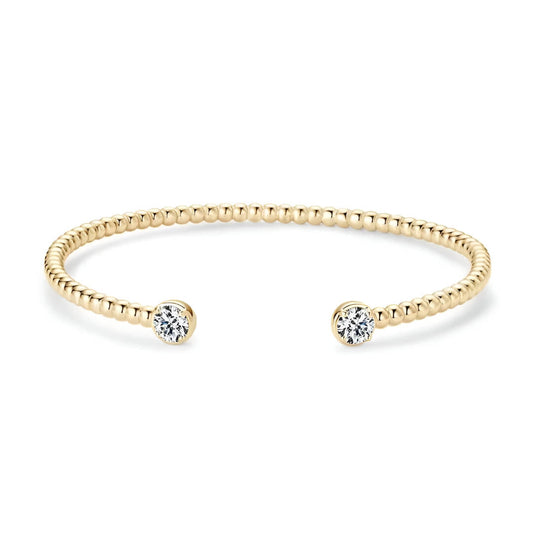 Jonc granulé en argent 925 plaqué or jaune et double diamants en moissanite forme ronde sur fond blanc.