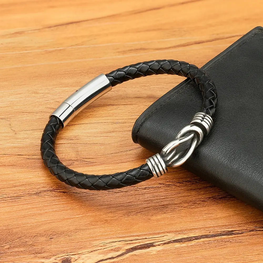 Bracelet liaison nœud argenté en cuir  noir tressé et acier inoxydable plaqué titane posé.