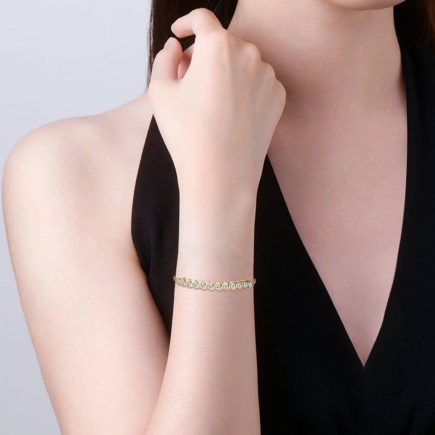 Bracelet maille fluide en argent 925 plaqué or jaune et diamants porté au poignet d'une femme.