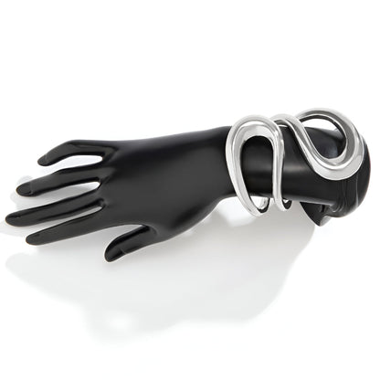 Bracelet manchette ajustable en or blanc porté au poignet d'un mannequin.