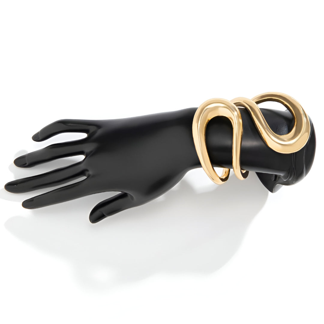 Bracelet manchette ajustable en or jaune porté au poignet d'un mannequin.