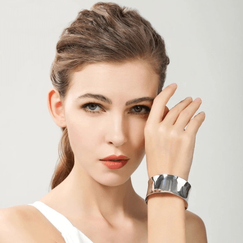 Bracelet manchette ouvert en argent 925 blanc porté au poignet d'une femme.