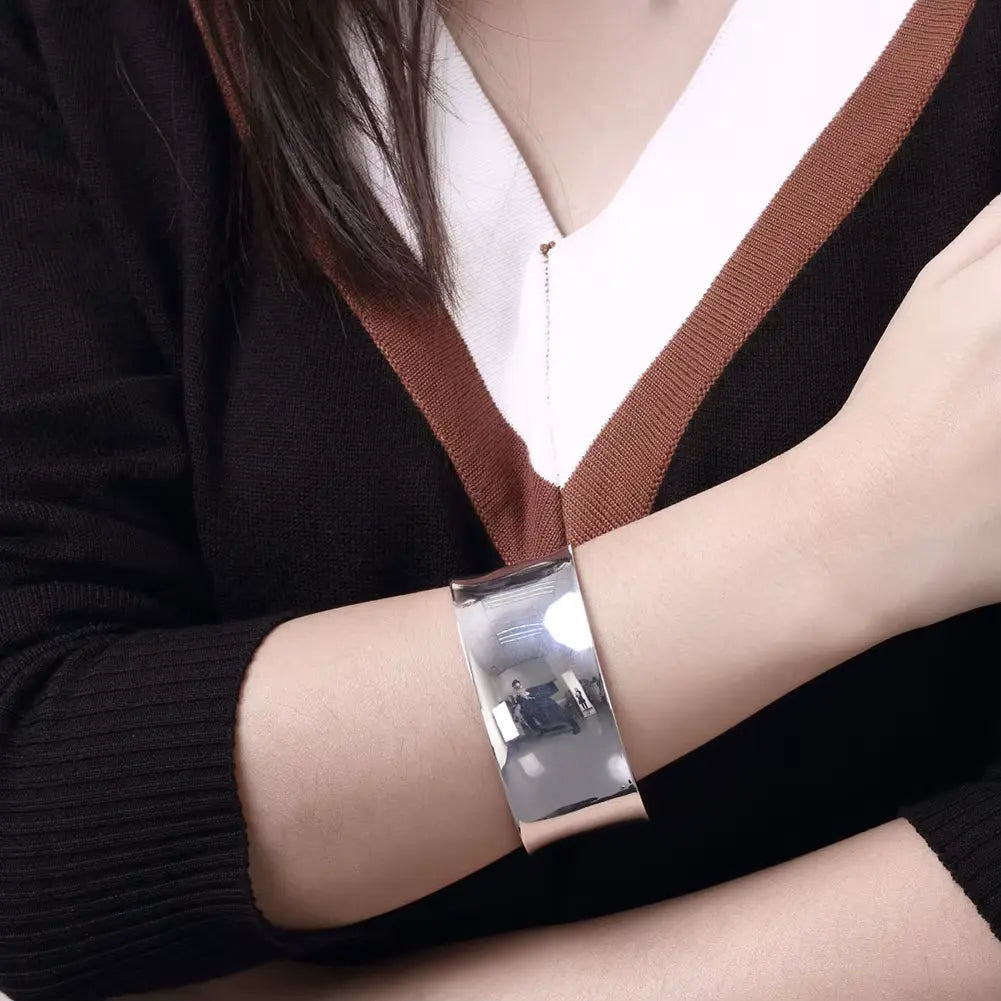 Bracelet manchette ouvert en argent 925 blanc porté au poignet d'une femme vue de proche.