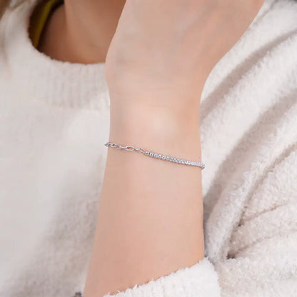 Bracelet semi-tennis chaîne cheval en argent 925 plaqué or blanc et moissanites porté au poignet d'une femme.