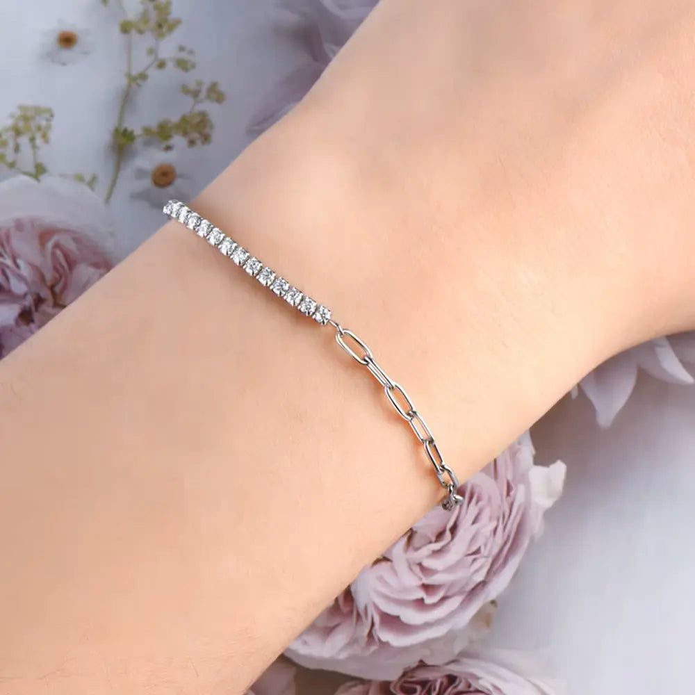 Bracelet semi-tennis chaîne cheval en argent 925 plaqué or blanc et moissanites porté au poignet d'une femme vue de proche.
