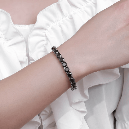 Bracelet tennis diamants noirs de moissanite en argent 925 plaqué or blanc variante 1ct porté au poignet d'une femme.