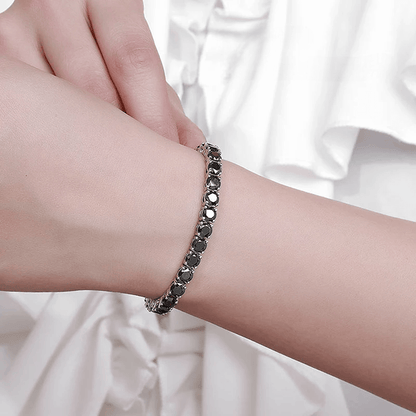 Bracelet tennis diamant noir en argent plaqué or blanc variante 0.5 carat porté au poignet d'une femme.