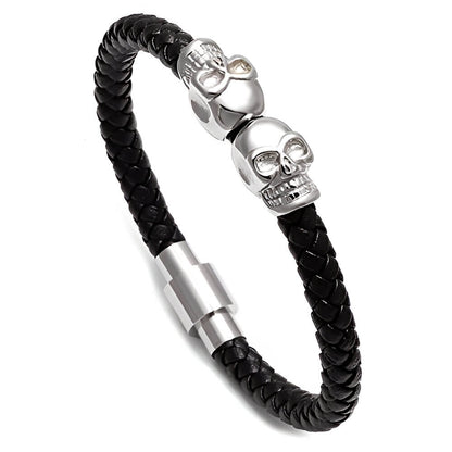 Bracelet tête de mort en cuir tressé noir et acier inoxydable plaqué titane blanc sur fond blanc.