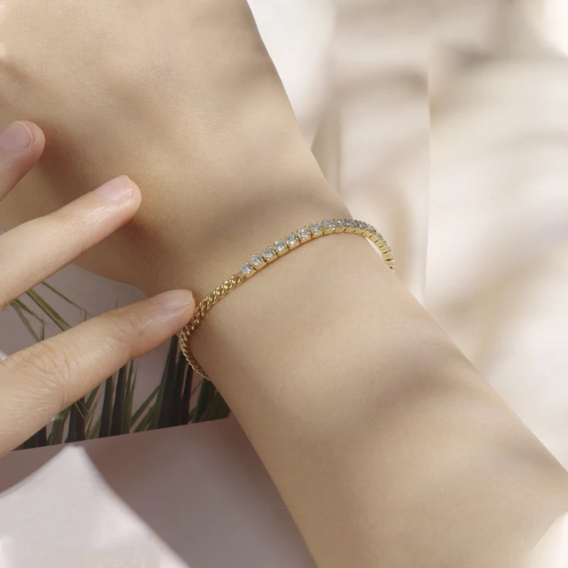 Chaîne cubaine en or jaune et diamants synthétiques portée au poignet d'une femme.