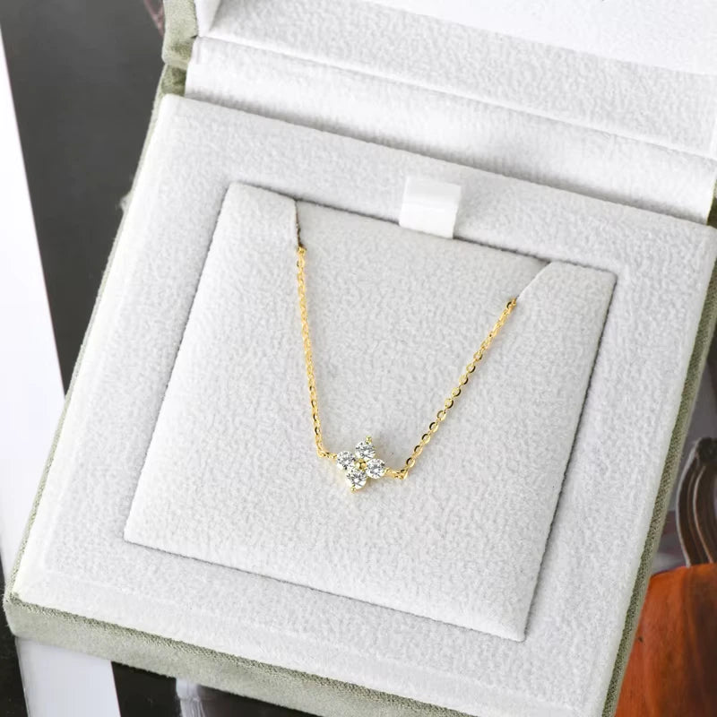 Chaîne fleur solitaire en or jaune et diamants synthétiques dans son écrin.