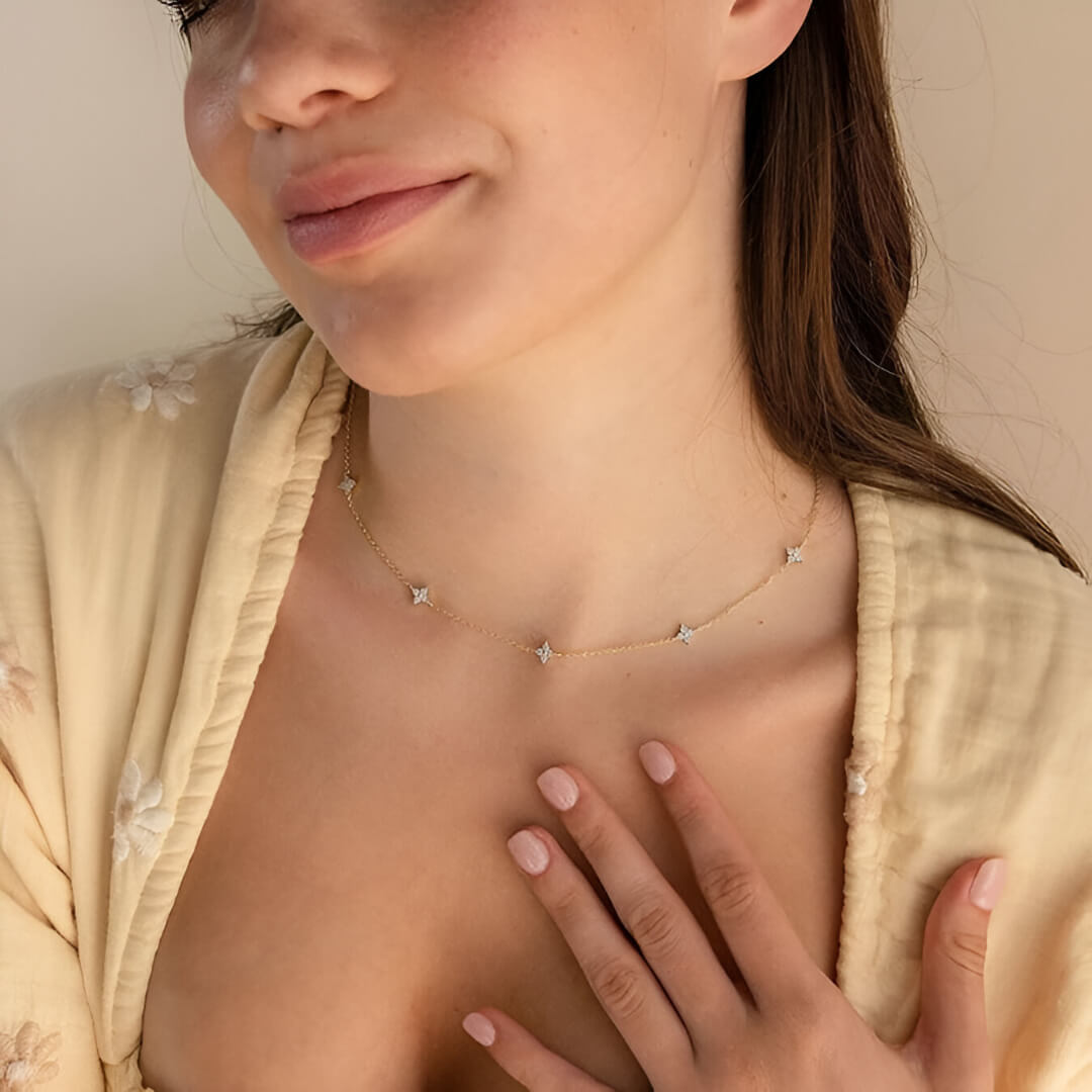 Chaîne fleurs de diamants naturels en or jaune portée au cou d'une femme vue de face.