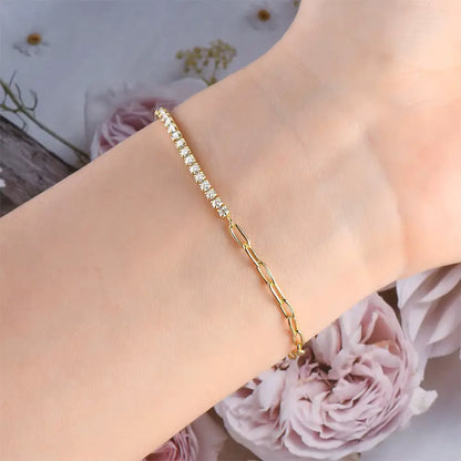 Chaîne maille cheval en or jaune et diamants synthétiques portée au poignet d'une femme vue de proche.