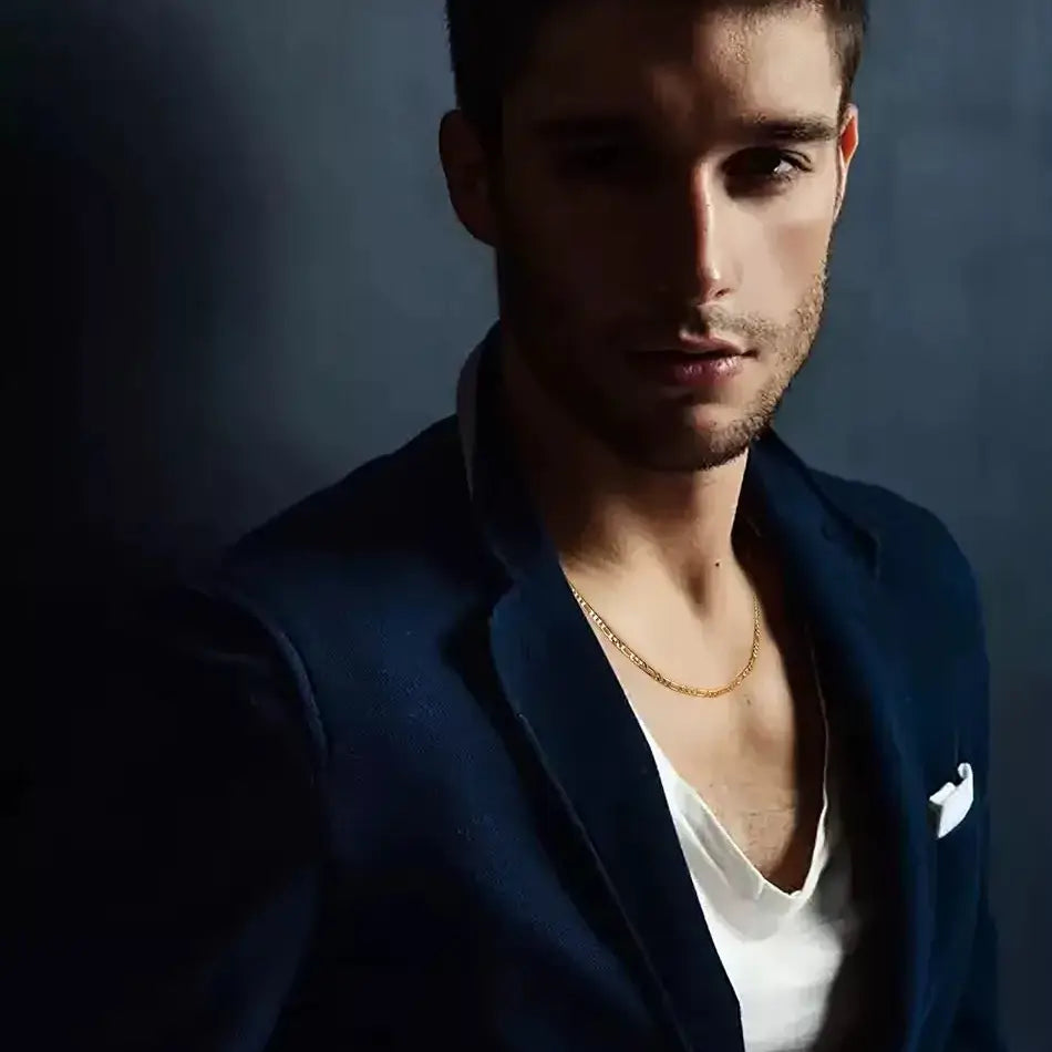 Chaîne maille figaro en argent sterling plaqué or jaune portée au cou d'un homme.