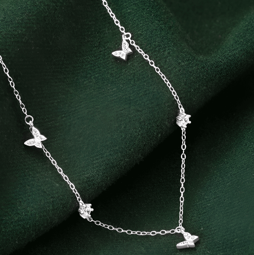 Chaîne papillons en or blanc et diamants naturels posée.