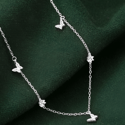 Chaîne papillons en or blanc et diamants naturels posée.