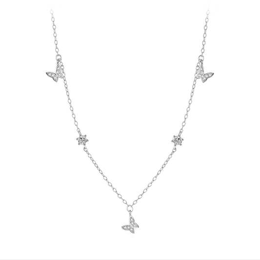 Chaîne papillons en or blanc et diamants naturels sur fond blanc.