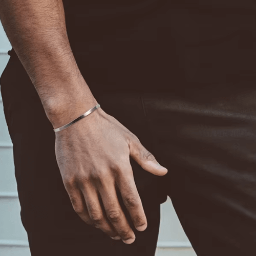 Chaîne serpent en argent plaqué or blanc portée au poignet d'un homme.