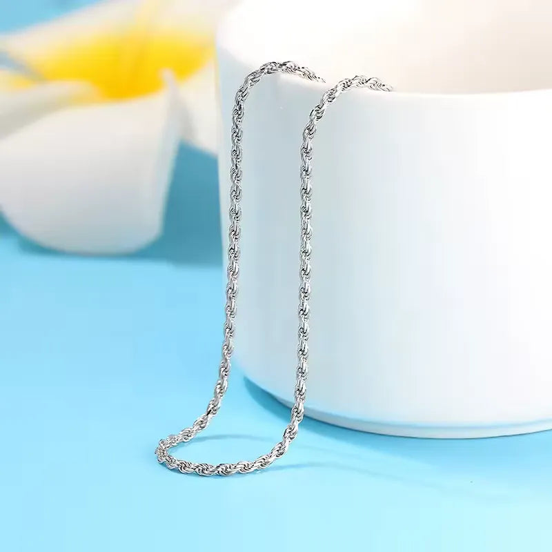 Chaîne torsadée en argent plaqué or blanc posée.
