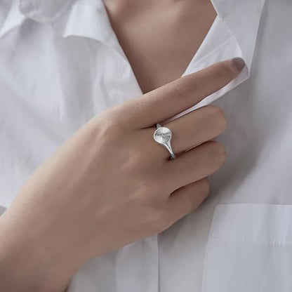 Chevalière pavé arrondi rainuré en acier inoxydable 316L plaqué titane portée au doigt d'une femme.