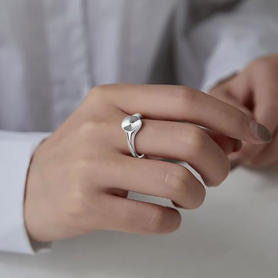 Chevalière pavé arrondi rainuré en acier inoxydable 316L plaqué titane portée au doigt d'une femme vue de face.