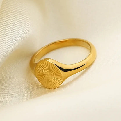 Chevalière pavé arrondi rainuré en acier plaqué or jaune vue de côté.