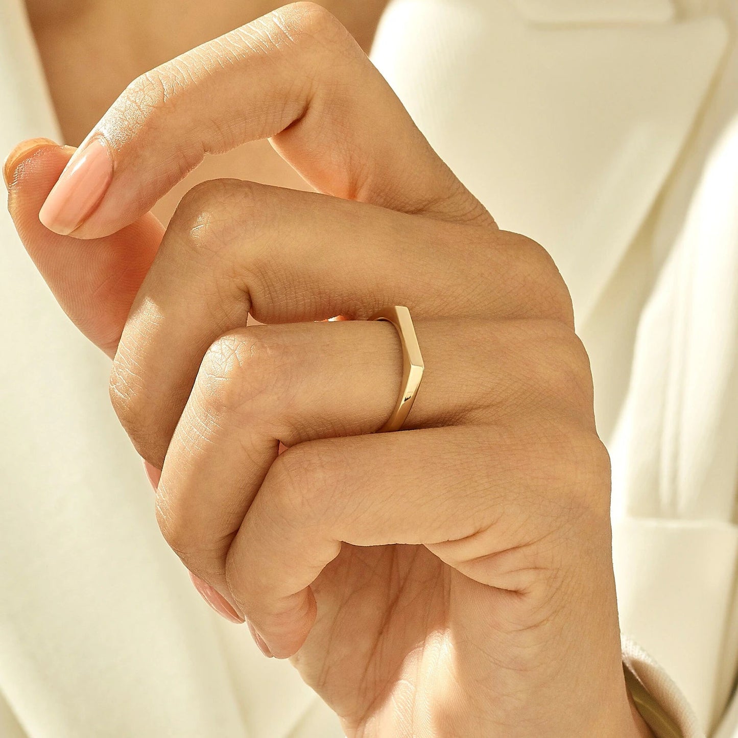 Bague chevalière pavé fin en acier plaqué or jaune portée au doigt 'une femme.