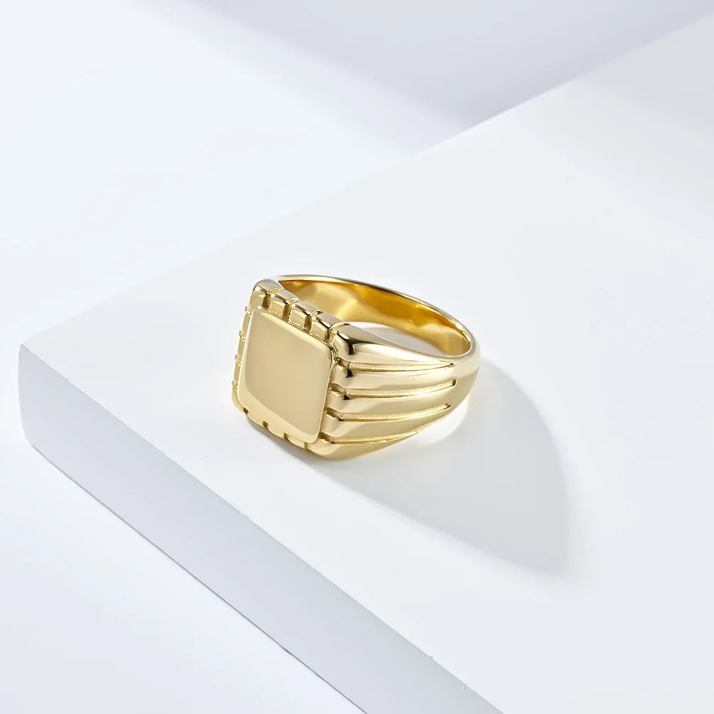 Chevalière pavé rainuré en acier doré vue de côté.