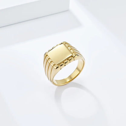 Chevalière pavé rainuré en acier doré debout.