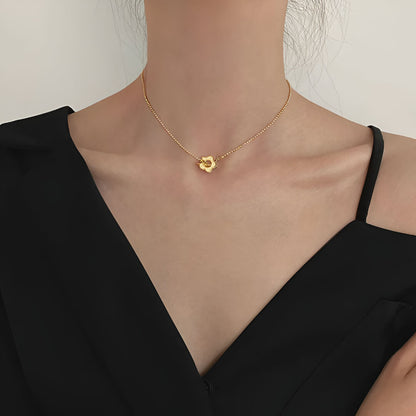 Collier choker fleur de marguerite en acier inoxydable plaqué or jaune porté au cou d'une femme.