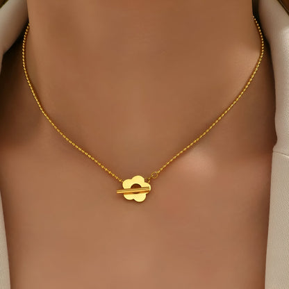 Collier choker fleur de marguerite en acier inoxydable plaqué or jaune porté au cou d'une femme vue de face.