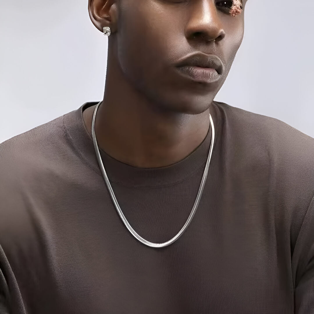 Collier à chaîne en acier inoxydable porté au cou d'un homme vue de face.