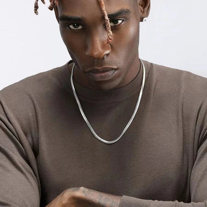 Collier à chaîne en acier inoxydable porté au cou d'un homme vue de loin.