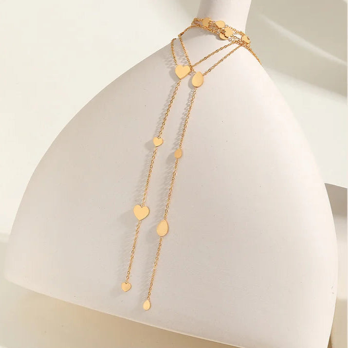 Collier cœur en acier inoxydable doré sur une jarre.