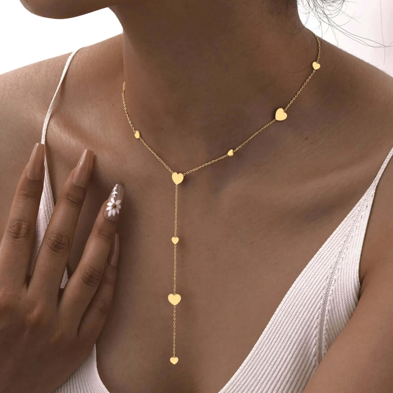 Collier cœur en acier inoxydable doré porté au cou d'une femme.
