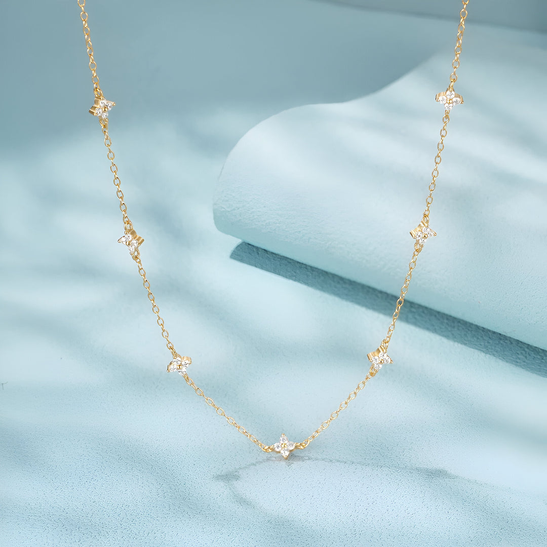 Détail du pendentif étoilé du Collier Constellation en argent 925 et or 18k avec moissanite éclatante sur fond bleu – zoom chaîne dorée