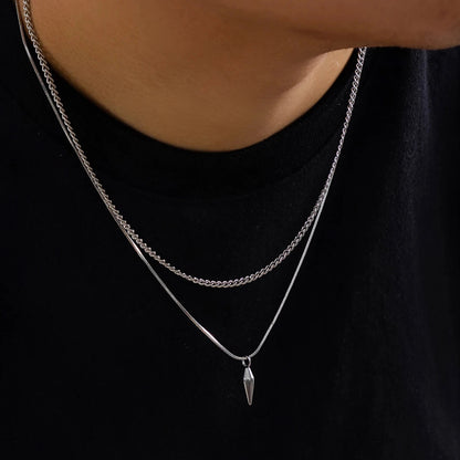 Collier double chaîne en acier inoxydable porté au cou d'un homme vue de proche.