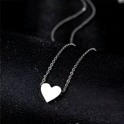 Collier fantaisie cœur en or blanc posé.