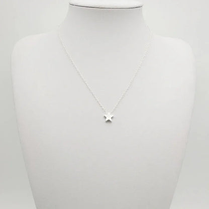 Collier fantaisie étoile en or blanc porté par un mannequin.