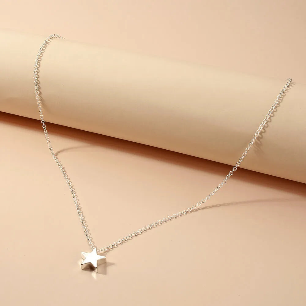 Collier fantaisie étoile en or blanc posé.