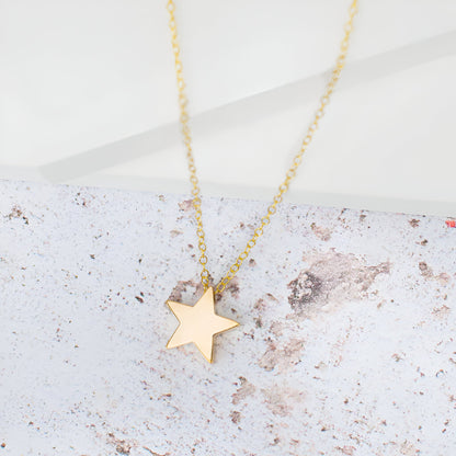 Collier fantaisie étoile en or jaune à plat.