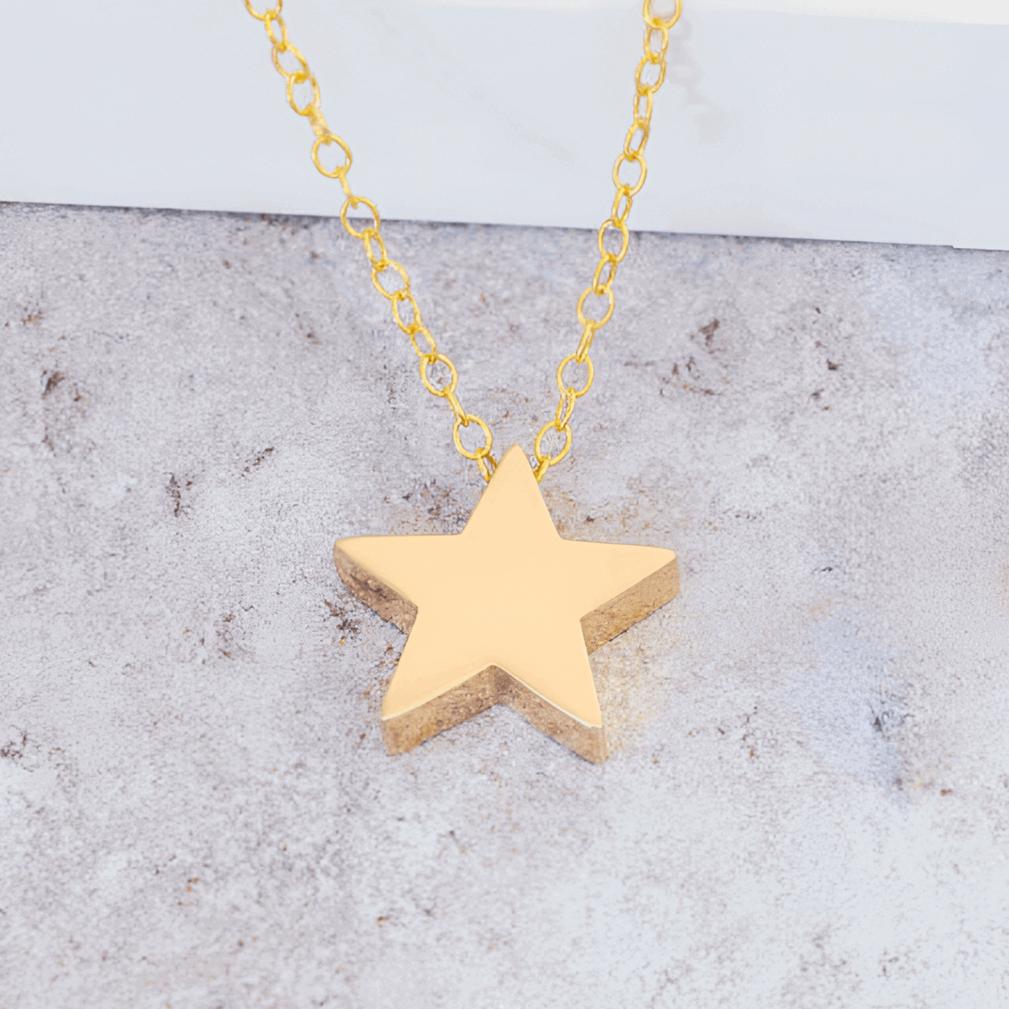 Collier fantaisie étoile en or jaune à plat vue rapprochée.