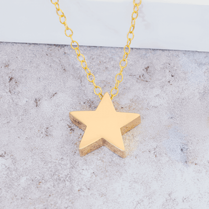 Collier fantaisie étoile en or jaune à plat vue rapprochée.