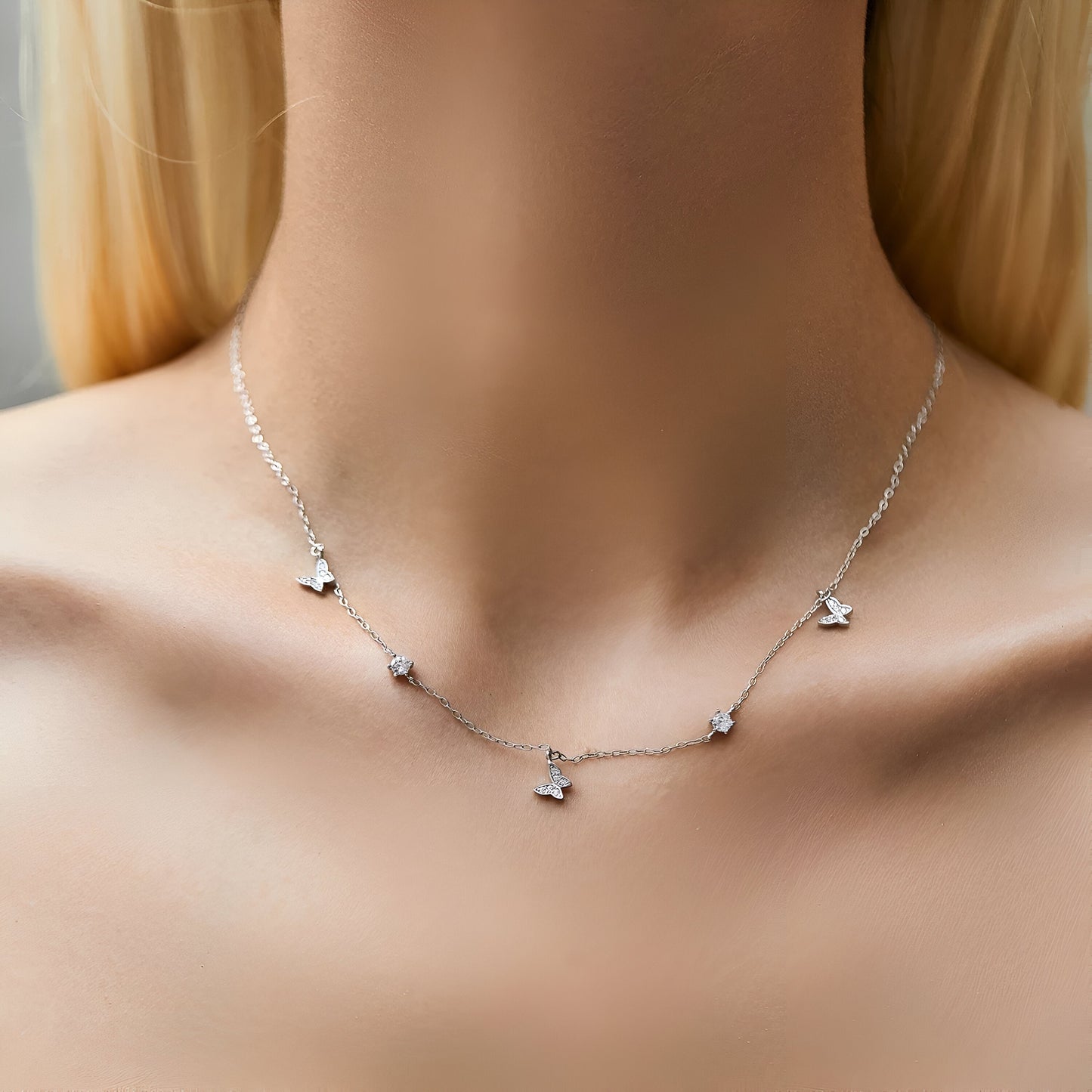 Collier fantaisie papillons en argent sterling 925 porté au cou par une femme – rendu élégant et délicat